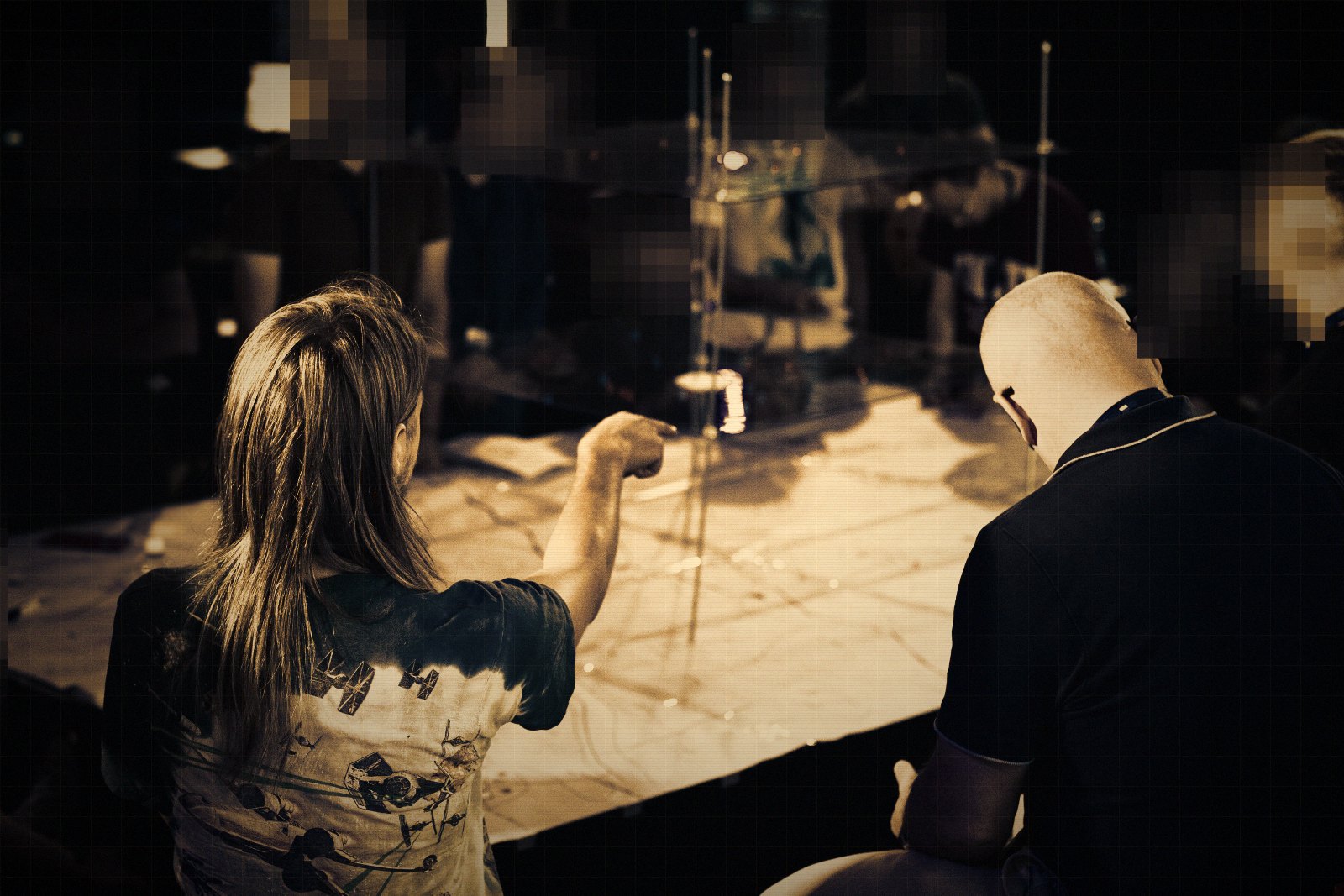 A player pointing at the map to explain a move while the rest of the table watches. Faces are obscured.